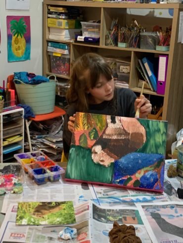 A teen showing her painting
