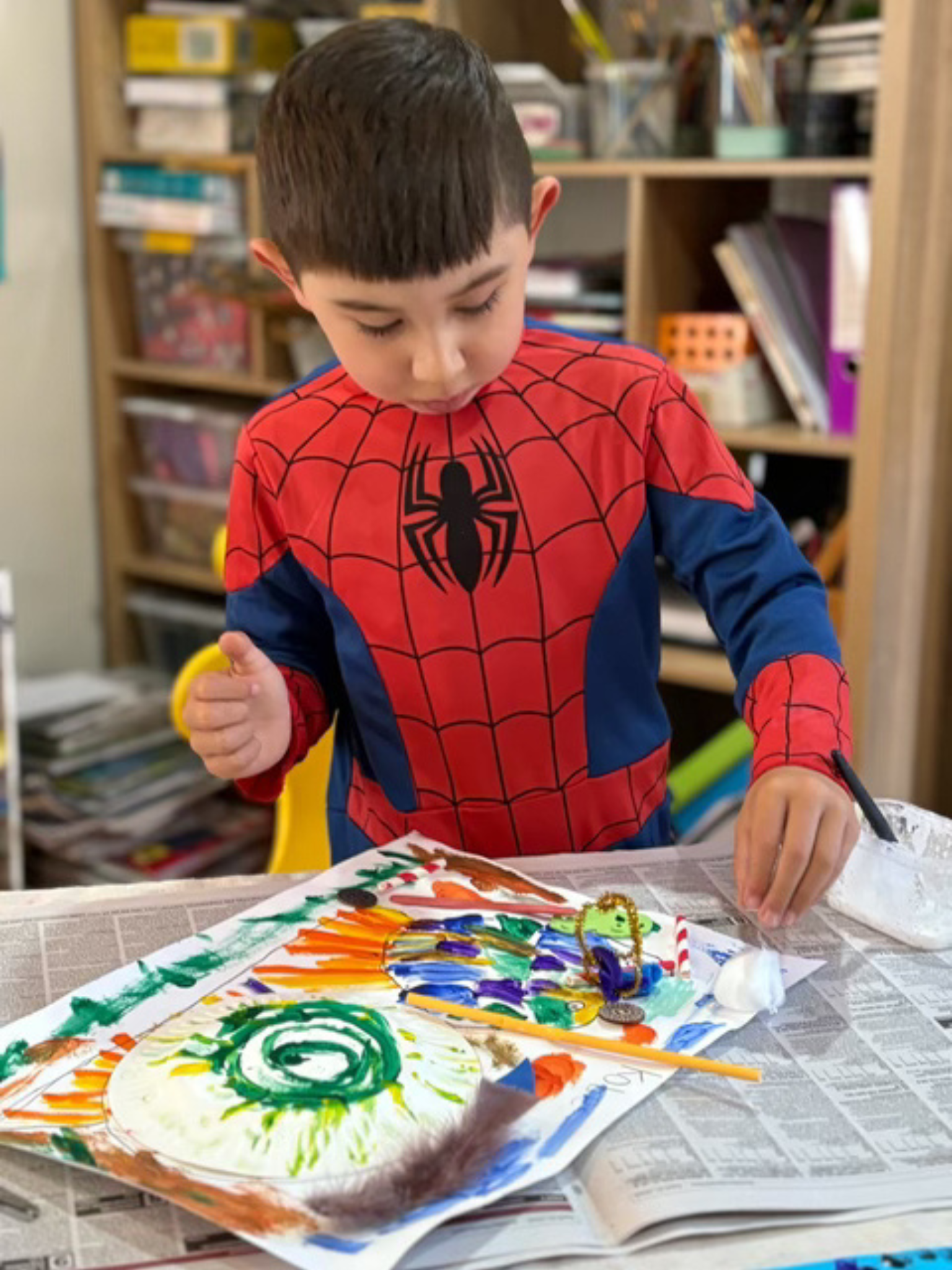 A Wild at Art KIDS student wearing a Spider-Man costume while painting.